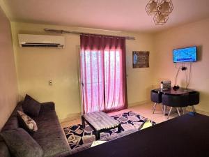 a living room with a couch and a table and a desk at Lasirena in Ain Sokhna