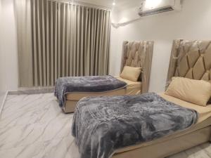 a room with two beds and a window at غرف عزاب وشقق عوايل in Riyadh