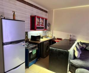 a small kitchen with a refrigerator and a stove at Lasirena in Ain Sokhna