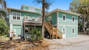 a green house with a porch and a deck at Treehouse at BootLegger Cove in Bluffton