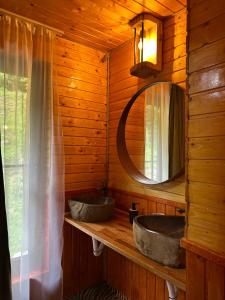 a bathroom with two sinks in a log cabin at Hecaș Villas in Caşoca +101 photos
