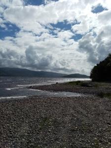 a rocky beach with a cloudy sky and water at Refugió Chaicura in Chonchi +6 photos
