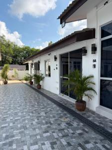 a white house with potted plants in front of it at D' Ehsan Homestay & Chalet in Kuala Terengganu