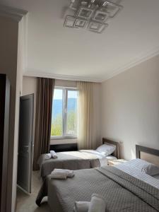 a hotel room with three beds and a window at Guest House in Halidzor