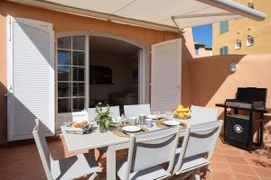 a white table and chairs on a patio at Port-Grimaud - La Maisonnette - sur plage et front de mer in Grimaud
