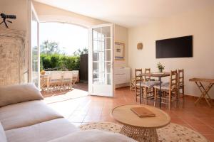 a living room with a couch and a table at Port-Grimaud - La Maisonnette - sur plage et front de mer in Grimaud
