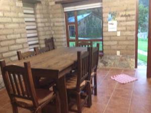 comedor con mesa de madera y sillas en Cabañas Hojarasca, en Mineral del Chico