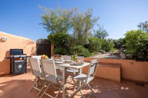 a table and chairs on a patio with a grill at Port-Grimaud - La Maisonnette - sur plage et front de mer in Grimaud