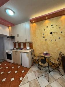 a kitchen with a table and a clock on the wall at Casa Di Porto in Kotor +2 photos
