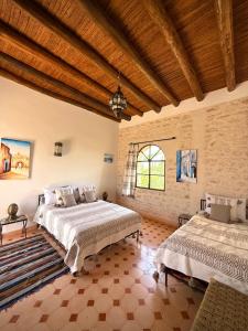 a large bedroom with two beds and a wooden ceiling at Riad Titima Essaouira in Essaouira +110 photos