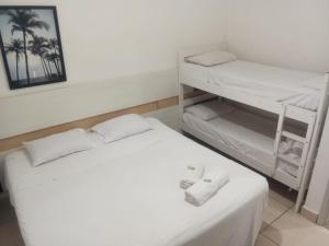 a room with a bed and bunk beds with towels at Hotel Natal in Santos +9 photos