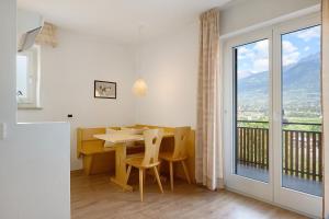 a dining room with a table and a large window at Ferienappartement Freiblick in Marlengo