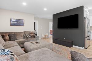 a living room with a couch and a flat screen tv at Good Lodge - Hot Tub Beach Access Pool Table in Lake Harmony