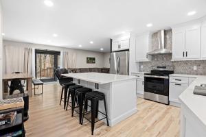 a kitchen with white cabinets and bar stools at Good Lodge - Hot Tub Beach Access Pool Table in Lake Harmony