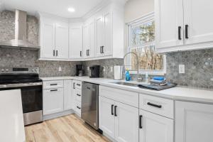 a white kitchen with white cabinets and a sink at Good Lodge - Hot Tub Beach Access Pool Table in Lake Harmony