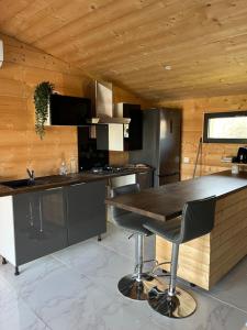 a kitchen with a wooden ceiling and a wooden table at Chalet in Fleury-sur-Loire