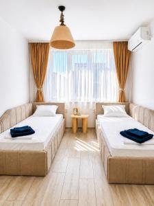 a room with two beds and a window at Апартамент Tiana 2 in Tsarevo