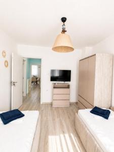 a living room with two beds and a tv at Апартамент Tiana 2 in Tsarevo +4 photos
