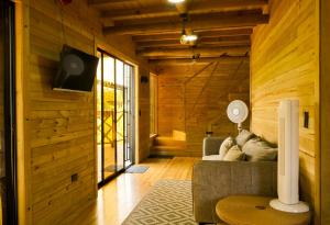 a living room with a couch and a tv at El Canto del Manglar in Nuquí