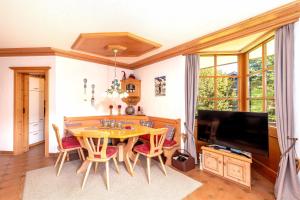 a dining room with a table and chairs and a television at Ferienwohnung Elisabeth in Reit im Winkl