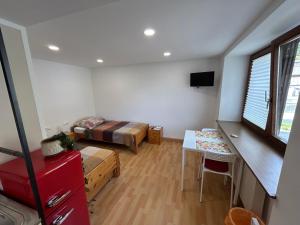 ein Zimmer mit einem Bett, einem Schreibtisch und einem Tisch in der Unterkunft Werkblick in Niederaigen