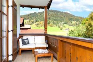 a porch with a white chair and a table at Ferienwohnung Elisabeth in Reit im Winkl