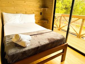 a bed in a log cabin with a window at El Canto del Manglar in Nuquí