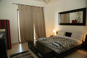a bedroom with a bed and a mirror on the wall at Apartment at Samarah Resort DeadSea C13-Families & couples only in Sowayma +68 photos