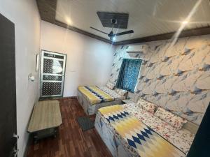 a room with two beds and a stone wall at Hotel karishna palace in Rīngas