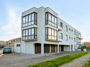 an apartment building with a car parked in a parking lot at Ringlaan 70 2V0201 in Wenduine