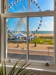 a window with a view of a ferris wheel at Marine Parade - Beach Apartment in Southtown
