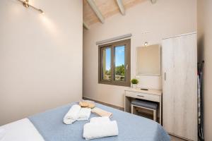 a bedroom with a blue bed with towels on it at Villa Angela in Trapezaki