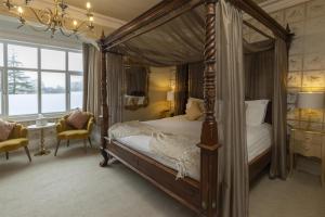 a bedroom with a four poster bed and a chandelier at The Riverside, WorldHotels Distinctive in Salisbury +74 photos