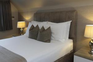 a bedroom with a large bed with white pillows at The Riverside, WorldHotels Distinctive in Salisbury