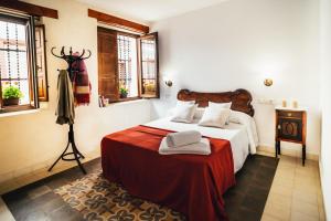 a bedroom with a large bed with a red blanket at La Casa del Boticario in Alcalá del Júcar