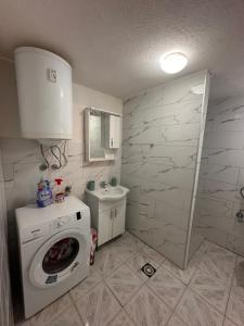 a bathroom with a washing machine and a sink at Guest House GURI in Vusanje