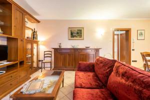 a living room with a red couch and a table at Appartamento Mary Monte Grappa in Borso del Grappa