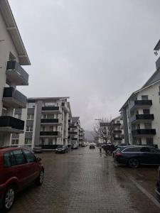 a parking lot with cars parked in front of buildings at Apartament AMNA Rasnov in Râşnov
