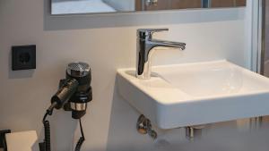 a hair dryer is hanging next to a sink at Roatel Helmstedt A2 my-roatel-com in Helmstedt
