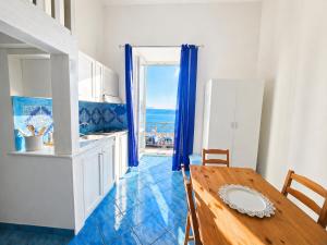 a kitchen with a wooden table and a dining room at Maridea - Spiaggia Sant' Antonio in Ponza +17 photos