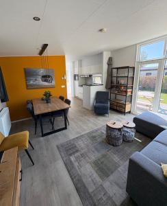 a living room with a couch and a table at Knus chalet Heidebloem Recreational purposes only in Putten