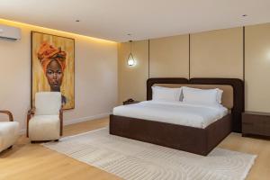 a bedroom with a bed and a painting on the wall at Seashell Suites in Abuja