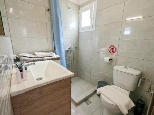 a bathroom with a toilet and a sink and a shower at Christiana's House in Artemida +19 photos