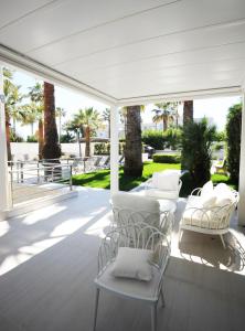 a white patio with white chairs and tables at THE FLOWERs in Pontecagnano