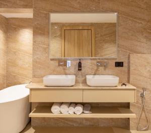 a bathroom with two sinks and a tub and a mirror at Seashell Suites in Abuja +31 photos