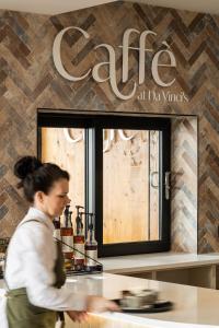 a woman standing behind a counter at a coffee shop at Da Vinci's Hotel in Derry Londonderry