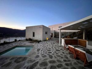 a house with a swimming pool on a patio at Galini House Private Villa in Andros in Órmos