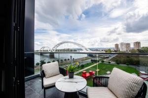 a balcony with chairs and a view of a bridge at Premium Hotel, Novi Sad in Novi Sad