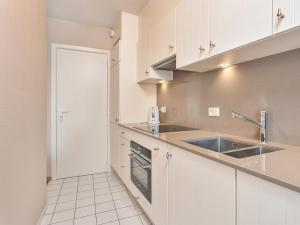 a kitchen with white cabinets and a sink at Beaufort 0401 in Wenduine