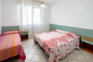 a bedroom with two beds and a window at Residenza Stella Y in Bibione